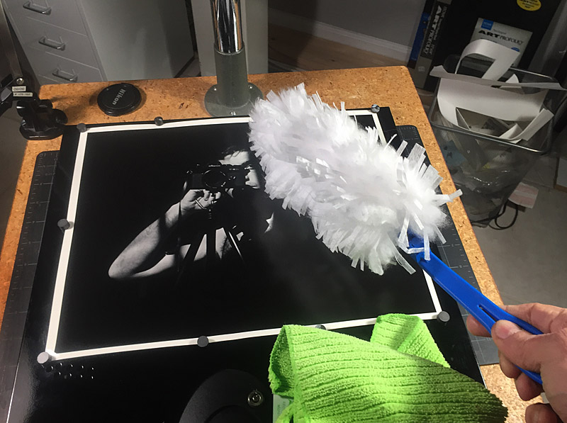I used a computer side panel under the print to both raise the image a bit and to allow the magnets to hold down the print edges. Keeping dust off the print is important. 